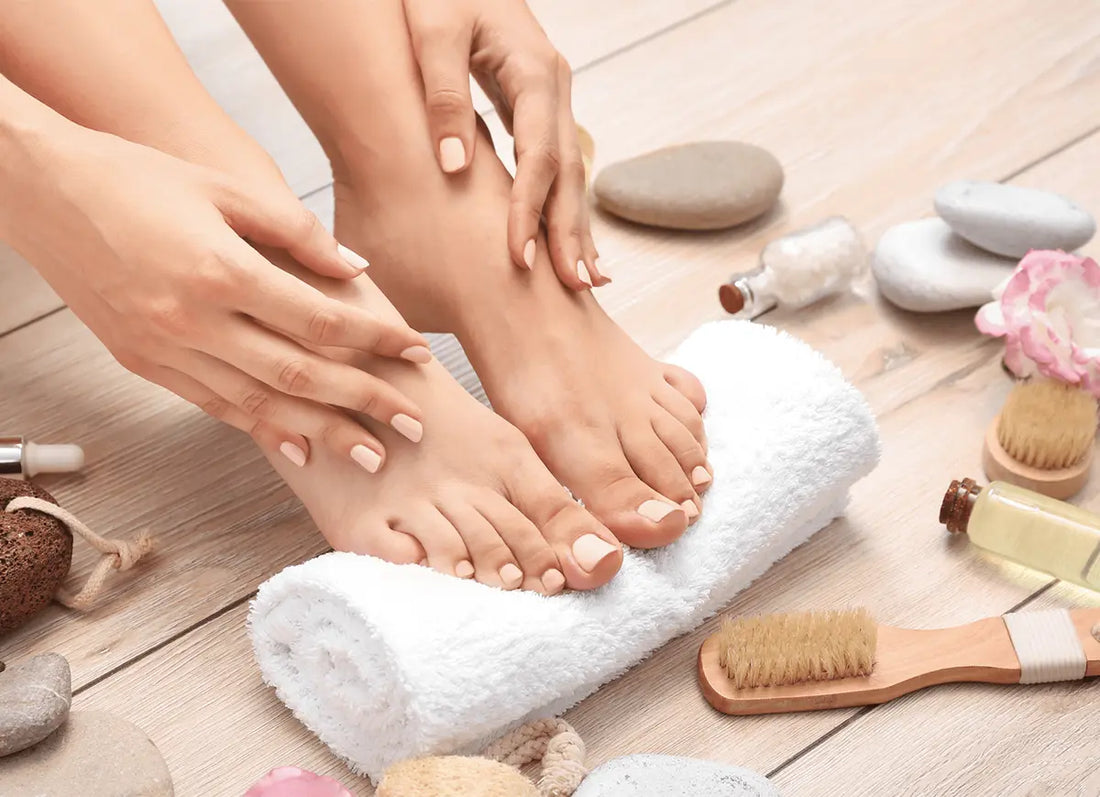 Woman Touching Feet on Towel by Home Foot Care Products.